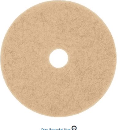 A tan colored circular pad with a small hole in the middle.